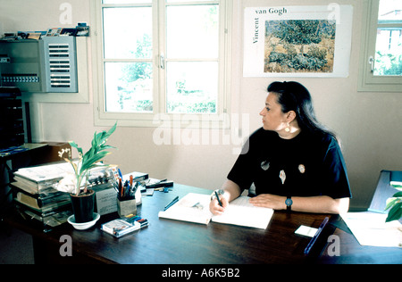 Femme assise, travaillant dans une maison de retraite pour personnes âgées surveillant les alarmes des patients Paris France Think Office Busy Desk, maison de retraite, téléassistance Banque D'Images