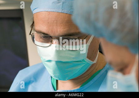 Médecins et infirmières se réunissent autour de la table pendant la chirurgie Banque D'Images