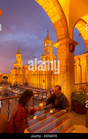 Un couple ayant un verre sur un balcon donnant sur la cathédrale Plaza de Armas au crépuscule Arequipa Pérou Banque D'Images