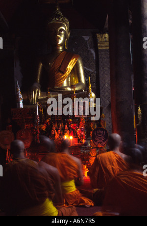 Adorant les moines un bouddha dans un Wat à Luang Prabang, Laos Banque D'Images