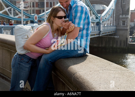 LONDON TOWER BRIDGE TOURISTES CONTRÔLE PHOTOGRAPHIES SUR TÉLÉPHONE MOBILE CELL PHONE Banque D'Images