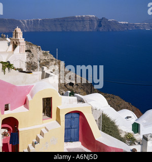 En vue d'Oia soleil tôt le matin, sur le bord supérieur des pentes arides falaises volcaniques rouges sur les îles grecques de Santorin Banque D'Images