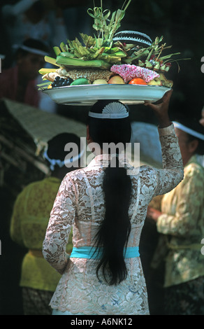 Femme balinaise arrive au temple avec une offrande religieuse fêtes de pleine lune Ubud Bali Indonésie Banque D'Images