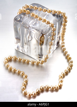 Un collier de perle drapé sur un cube de glace Banque D'Images