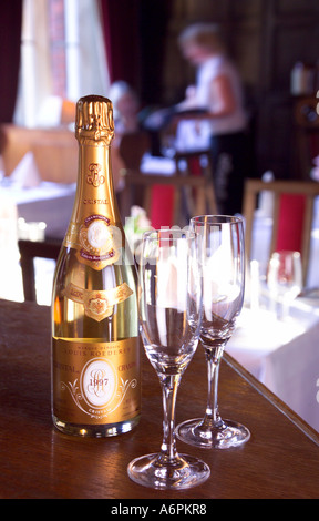 Bouteille de champagne CRISTAL LOUIS ROEDERER AVEC DEUX VERRES VIDES SUR UN BAR EN PAYS HÔTEL AVEC SERVEUSE EN ARRIÈRE-PLAN Banque D'Images