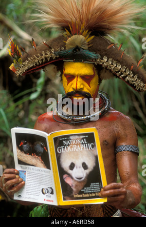 La Papouasie-Nouvelle-Guinée, Huli Wigman, Tribu. Plateaux du Sud, près de Tari, Man reading National Geographic à singsing Banque D'Images