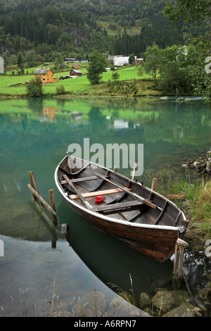 Un bateau à rames est attaché dans le miroir comme l'eau turquoise du lac Olden, Norvège Banque D'Images