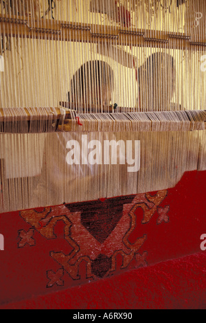 L'Afrique, Maroc, Ouarzazate, silhouette féminine nouage tapis berbère sur à tisser artisanale Ensemble Banque D'Images