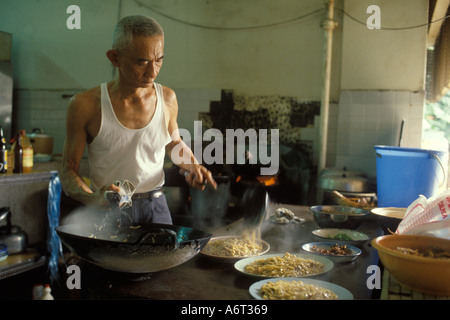 Singapour cuisine Chef ouvrier chinois dans le restaurant en plein air du marché préparant la nourriture. Vers septembre 1983 1980s HOMER SYKES Banque D'Images