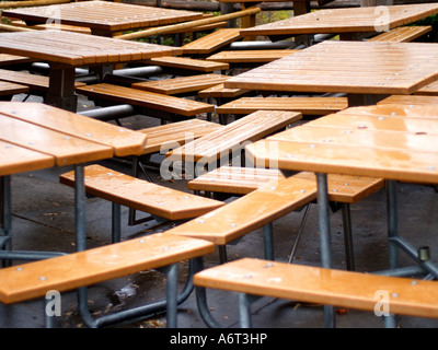 Des rangées et des rangées de tables de pique-nique en bois en plein air, à forte densité, organisé sous la pluie. Banque D'Images