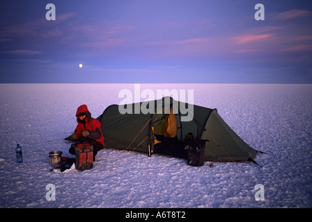 Femme prépare la nourriture sur camping femme prépare la nourriture sur l'extérieur réchaud de camping tente sur télévision sel déserte de Salar de Uyuni 3600 al Banque D'Images