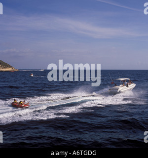 Fun in the sun avec nervure Charter Portal - donuts en remorque derrière Rigid Inflatable Boat - dans la baie de Palma près de Magalluf. Banque D'Images