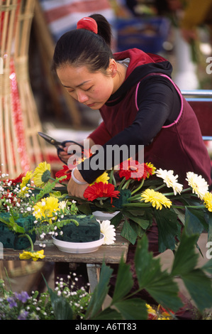 La Chine, le Yunnan, Kunming. Femme fleurs organise à ville marché aux fleurs Banque D'Images