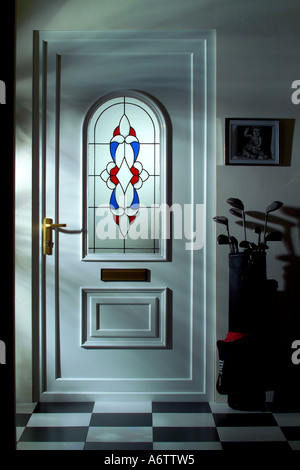 Couloir de la maison avec plancher en stratifié blanc et porte d'Upvc avec clubs de golf nuit Banque D'Images