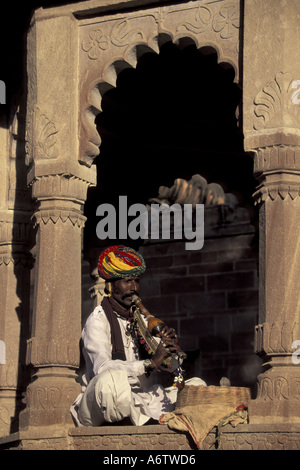 L'Asie, l'Inde, Rajasthan, Jodphur, charmeur de serpent indien Local assis sous arche en pierre, (MR) Banque D'Images