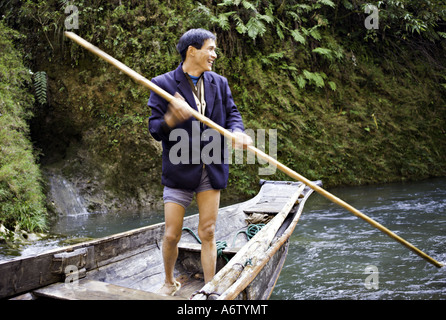 Chine Yangtze River batelier rit avec ses amis comme il saisit son pôle de bambou pour pousser son bateau peapod Banque D'Images