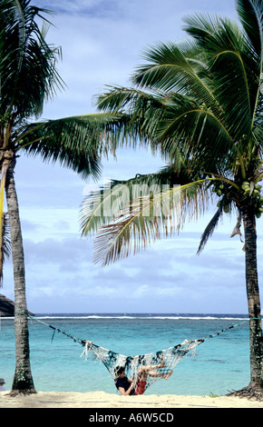 Tourisme,homme ,de vous détendre dans un hamac sur une plage, les Îles Cook, Pacifique Sud Banque D'Images