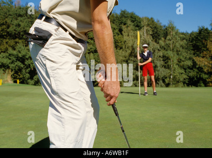 Cropped shot of young male golfer alignant au trou Banque D'Images