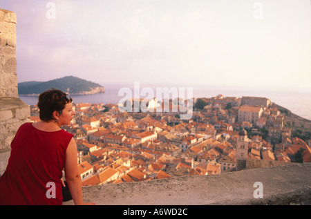 Une femme dans une robe rouge qui donne sur la vieille ville depuis les remparts Banque D'Images