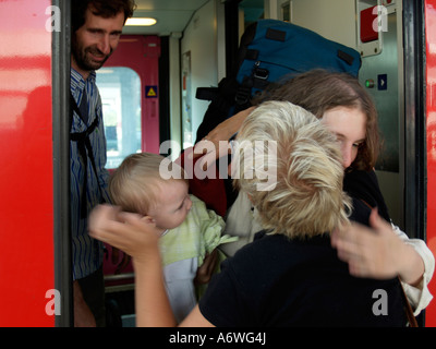 M. personnes deux femmes avec un petit enfant en adoptant par prendre congé de bienvenue à la porte d'un train Banque D'Images