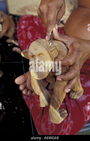 L'Asie, INDONÉSIE, Bali, Ubud. Un artisan près de la forêt des singes à Ubud sculpte les chimpanzés en bois Banque D'Images