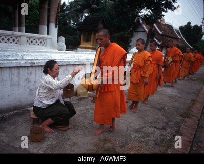 Les moines bouddhistes lao sur leur matin rondes de mendier l'aumône à des fins de subsistance. Banque D'Images