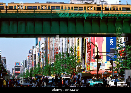 Un train passe sur un pont dans le quartier électronique d'Akihabara à Tokyo au Japon. Banque D'Images