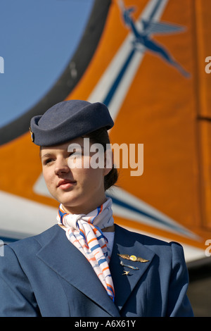 Hôtesse de l'air, dans les années 50 aux côtés des uniformes un vieux South African Airways DC-4. Banque D'Images