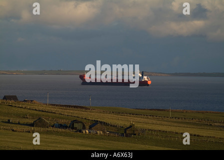 Dh oil tanker SHIPPING UK Oiltanker anchorage en attente de transfert d'huile à Scapa Flow et cottage Banque D'Images