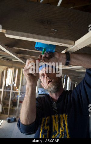 Faire du bénévolat de réparer le câblage dans la maison endommagée par l'ouragan Katrina Banque D'Images