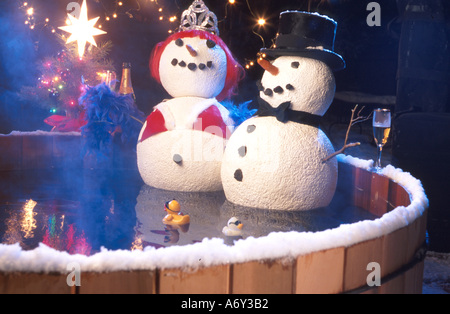 Deux Snowpeople assis dans un bain à remous célébrer les jours fériés Banque D'Images