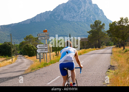 Mas de la Plaine, Mas Rigaud, Mas Bruguiere, le domaine de l'Hortus. Un homme à vélo. Le Pic St Loup montagne crête. Pic St Loup. Languedoc. La France. L'Europe. Banque D'Images