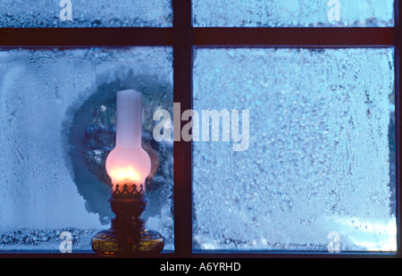 Lampe à pétrole à la fenêtre en hiver Banque D'Images