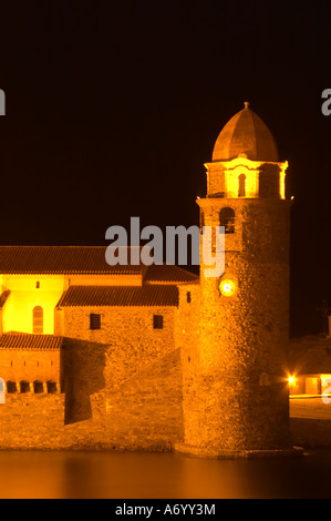 L'église Eglise Notre Dame des Anges, notre dame des anges. Avec son emblématique tour de l'église. Collioure. Roussillon. La France. L'Europe. Dans la soirée à l'allumage et l'éclairage de rue. Banque D'Images