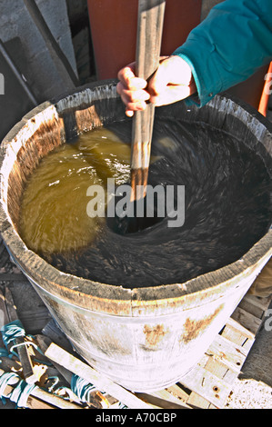 Bernard Bellahsen. Domaine Fontedicto, Caux. Région Pézenas. Languedoc. Un bio-dynamique dynamiser dynamiseur pour faire des infusions en le remuant un mélange de plantes et d'herbes dans l'eau. Propriétaire viticulteur. La France. L'Europe. Banque D'Images