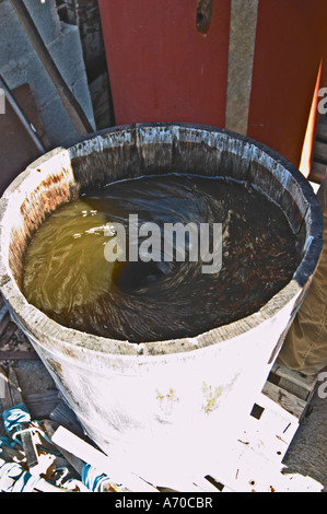 Domaine Fontedicto, Caux. Région Pézenas. Languedoc. Un bio-dynamique dynamiser dynamiseur pour faire des infusions en le remuant un mélange de plantes et d'herbes dans l'eau. La France. L'Europe. Banque D'Images