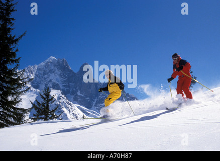 Groupe de deux skieurs masculins sur une piste sur une belle journée ensoleillée sans nuage Banque D'Images