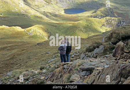 SNOWDON GWYNEDD NORD DU PAYS DE GALLES Royaume-Uni septembre jeune homme et femme sur la route de y Lliwedd dans le parc national EryriSnowdonia une zone de promenade très populaire Banque D'Images