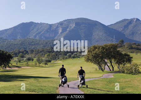 Alhaurin de la Torre, la province de Malaga, Costa del Sol à l'intérieur des terres, au sud de l'Espagne. Lauro Golf. Deux hommes marche sur chemin. Banque D'Images