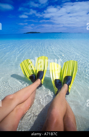 Deux paire de jambes avec des palmes de natation jaune sur les pieds Aitutaki Lagoon Cook Islands South Pacific Ocean model image parution Banque D'Images
