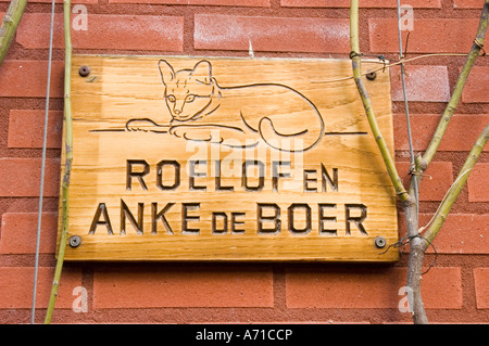 Assiette en bois sculptée avec chat à Leeuwarden, Frise, Hollande. Plaque signalétique pour Roelof et Anke de Boer montée sur un mur de briques rouges. Banque D'Images