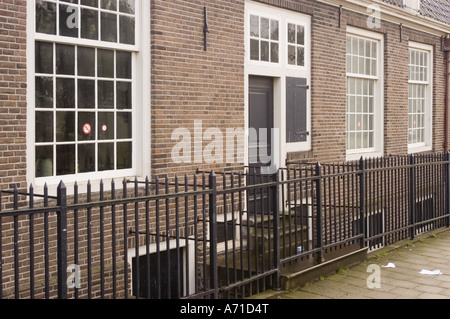 Extérieur de la synagogue portugaise dans l'ancien quartier juif Jodenbuurt, Amsterdam, Hollande, avec des murs de briques et une clôture en métal noir. Banque D'Images