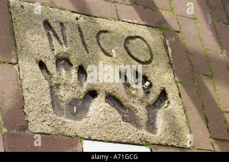 Dalle de béton avec des empreintes de mains et le nom Nico sculpté dedans, situé dans un trottoir de briques à Amsterdam, en Hollande. Banque D'Images