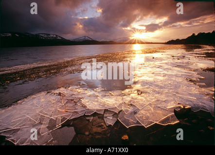 Coucher du soleil sur la banquise d'hiver après la débâcle sur le Loch Morlich Parc national de Cairngorm Ecosse Banque D'Images