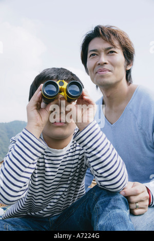 Père et fils à l'aide de jumelles Banque D'Images