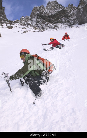 Les grimpeurs bum glisser hors de la grande pierre de tournage sur Sgurr Alasdair, Cuillin Ridge, Skye, Scotland, UK Banque D'Images