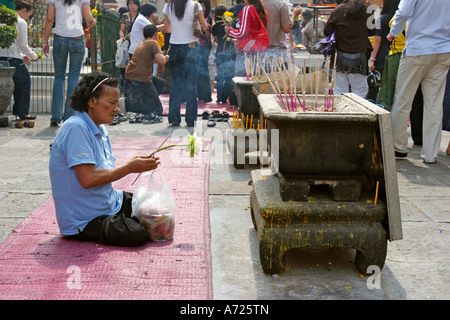 Femme en prière bouddhiste dans le temple de Wat Phra Kaeo. Bangkok, Thaïlande. Banque D'Images