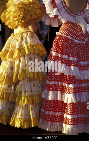 Espagne, Andalousie, Séville jaune et rouge robes de flamenco en rythme annuel Feria de Abril (Foire d'avril) Banque D'Images