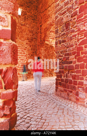 Woman walking through old town gate Portas da Cidade, Silves, Algarve, Portugal Banque D'Images