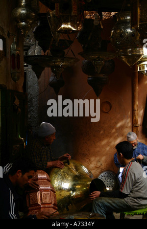 Les travailleuses et travailleurs de métal lampes traditionnelles dans des souks de Marrakech, Maroc, Afrique du Nord Banque D'Images